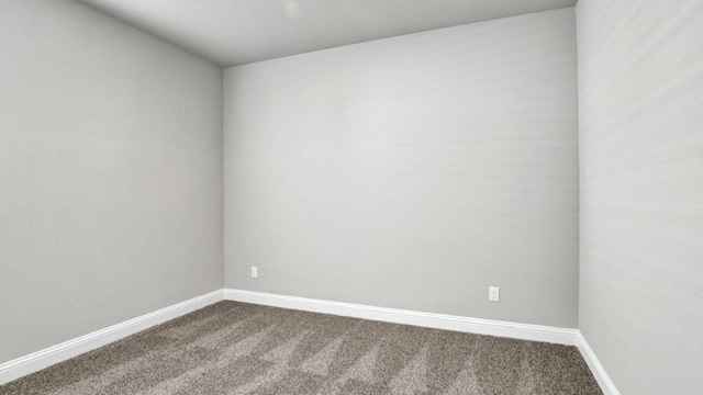 carpeted empty room featuring baseboards