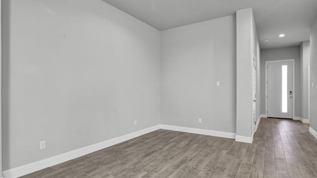 unfurnished room with recessed lighting, baseboards, and wood finished floors