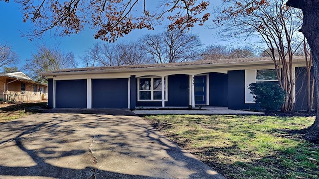 single story home with a garage, a front yard, concrete driveway, and a porch