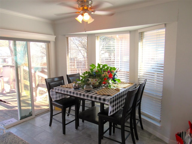 dining space with ornamental molding and a ceiling fan