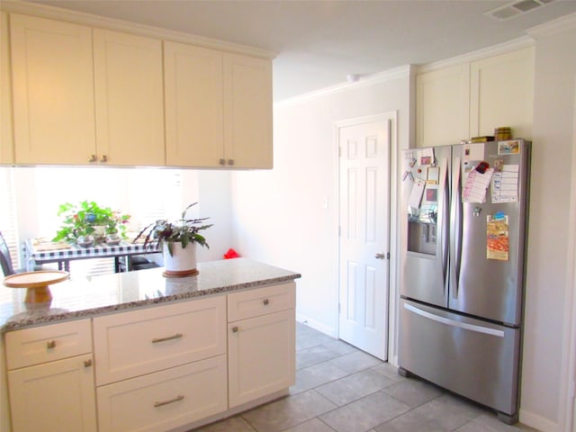 kitchen with light stone countertops, visible vents, crown molding, and stainless steel fridge with ice dispenser