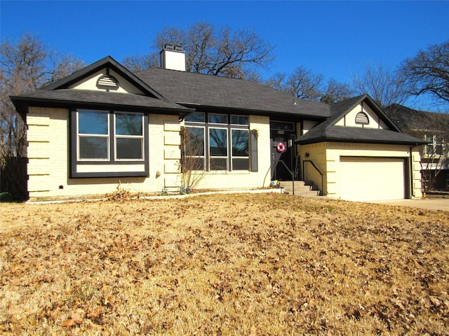 ranch-style home featuring a garage, a shingled roof, concrete driveway, a chimney, and brick siding