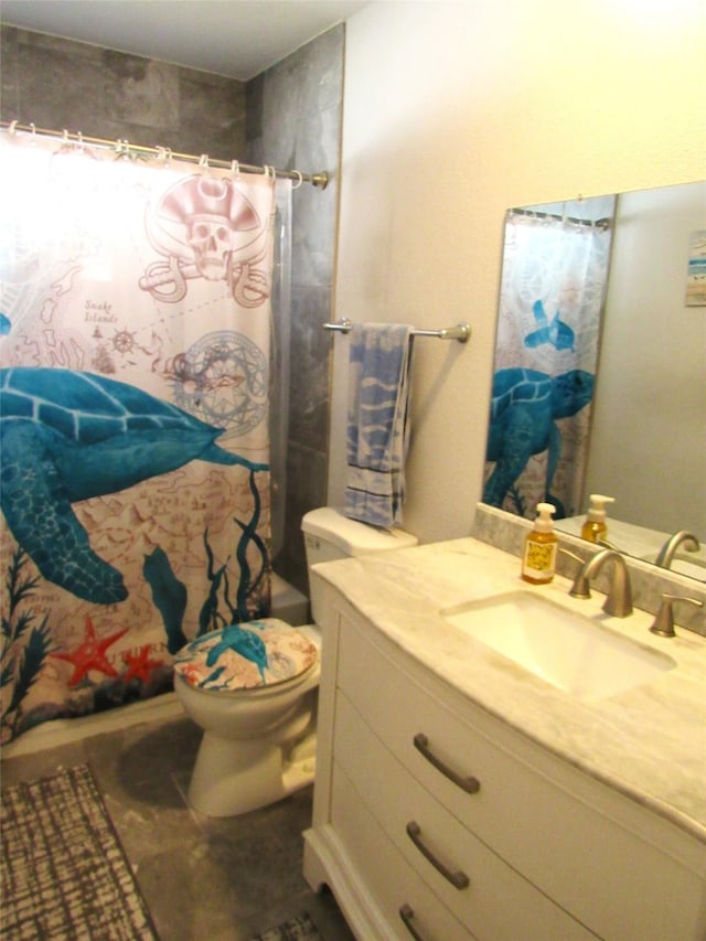 bathroom featuring toilet, a shower with shower curtain, and vanity