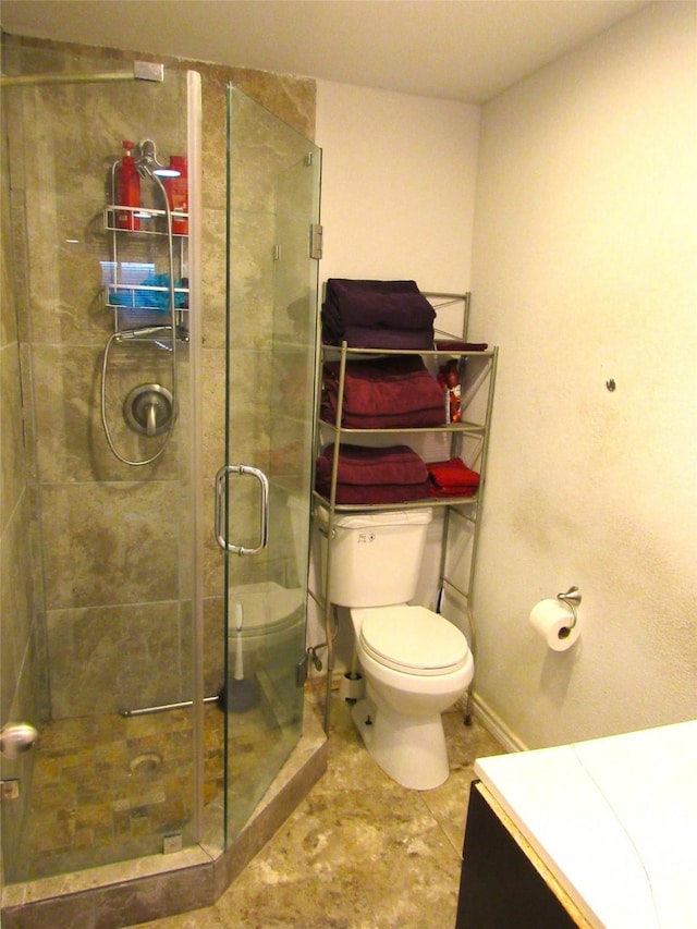 full bath with toilet, a stall shower, baseboards, and vanity