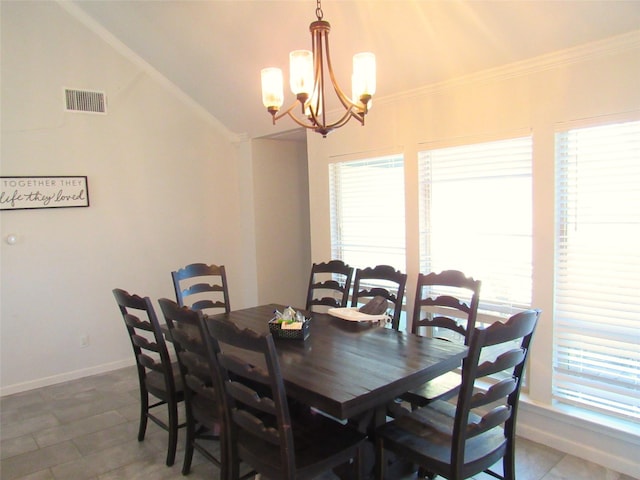 dining space with baseboards, visible vents, lofted ceiling, crown molding, and a chandelier