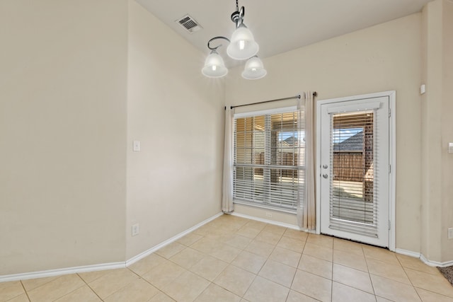 interior space with light tile patterned flooring, visible vents, baseboards, and an inviting chandelier