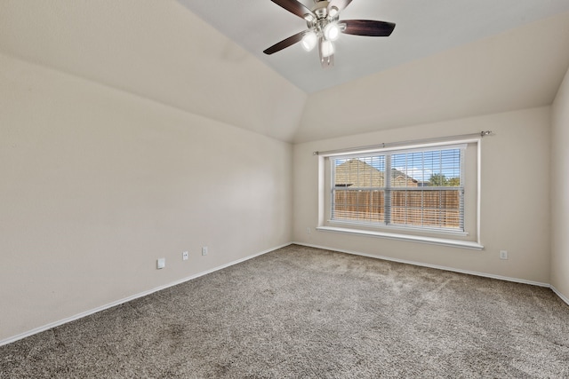 carpeted empty room with a ceiling fan, vaulted ceiling, and baseboards