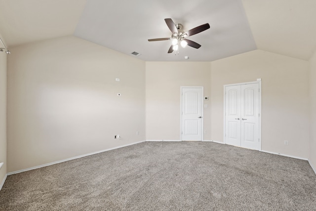 carpeted empty room featuring lofted ceiling, visible vents, ceiling fan, and baseboards