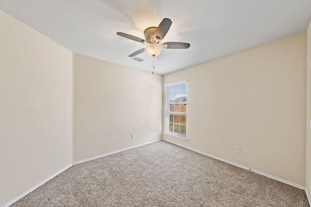 carpeted empty room featuring visible vents, ceiling fan, and baseboards