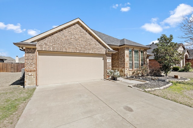 single story home featuring a garage, driveway, brick siding, and fence