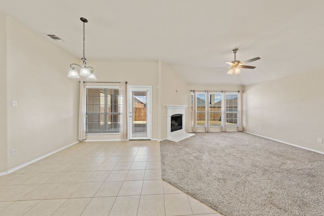 unfurnished living room with light tile patterned flooring, light carpet, ceiling fan with notable chandelier, a fireplace, and visible vents