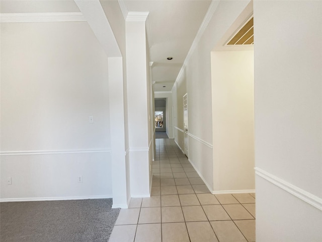 corridor featuring light tile patterned flooring, baseboards, and ornamental molding