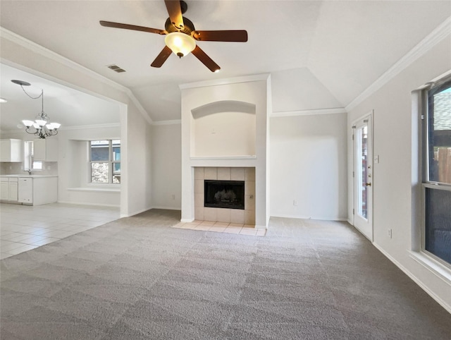 unfurnished living room featuring visible vents, light colored carpet, a fireplace, and crown molding