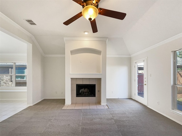 unfurnished living room featuring visible vents, carpet floors, ornamental molding, vaulted ceiling, and a tiled fireplace