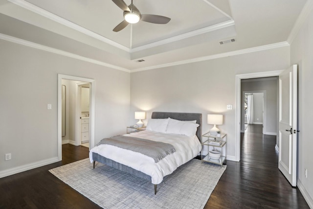 bedroom featuring baseboards, visible vents, dark wood-style flooring, and a tray ceiling