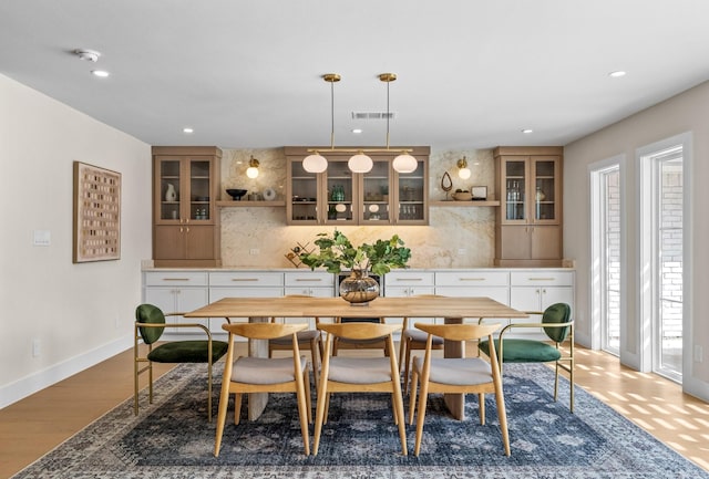 dining space featuring baseboards, wood finished floors, visible vents, and recessed lighting