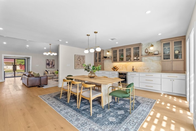 dining space featuring visible vents, wine cooler, light wood-type flooring, indoor wet bar, and recessed lighting