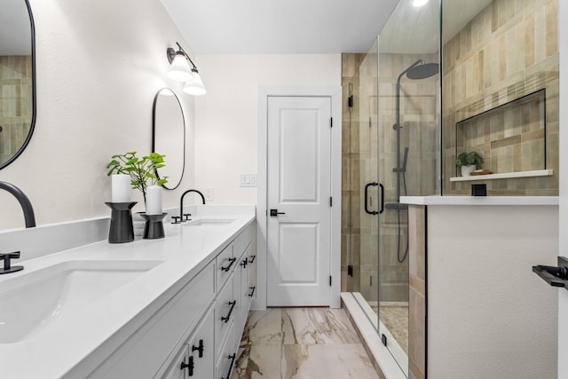 bathroom featuring double vanity, marble finish floor, a sink, and a stall shower