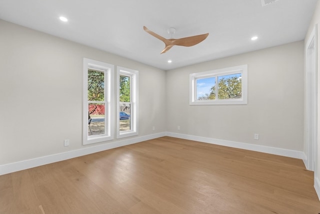 spare room with light wood-style floors, a healthy amount of sunlight, and baseboards