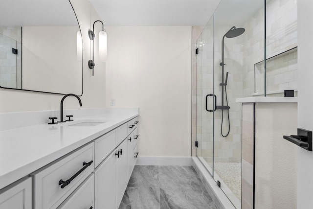 full bath featuring a shower stall, vanity, and baseboards