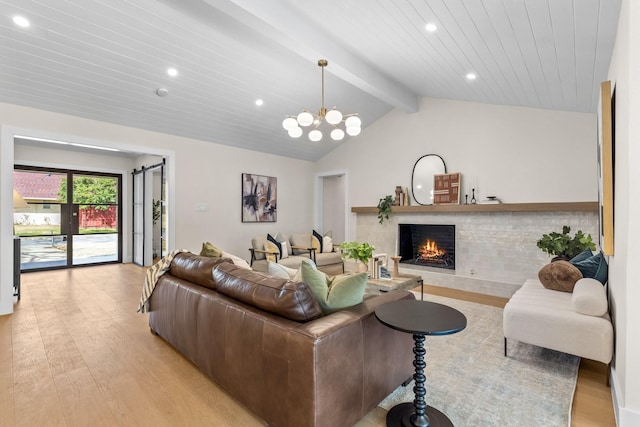 living area with a notable chandelier, vaulted ceiling with beams, recessed lighting, light wood-type flooring, and a warm lit fireplace