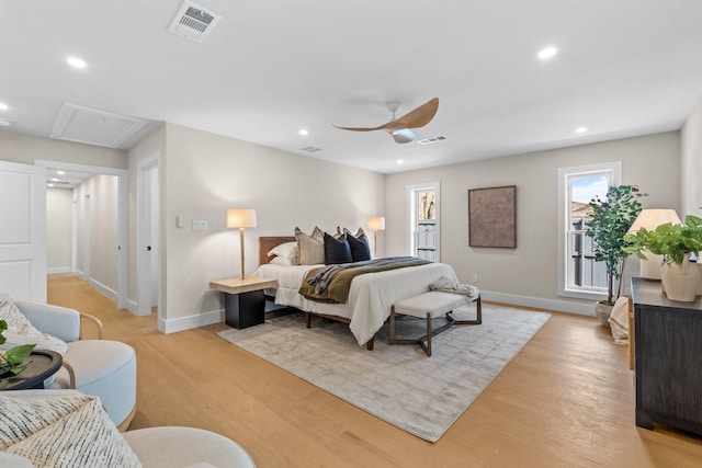 bedroom with attic access, light wood-type flooring, visible vents, and recessed lighting