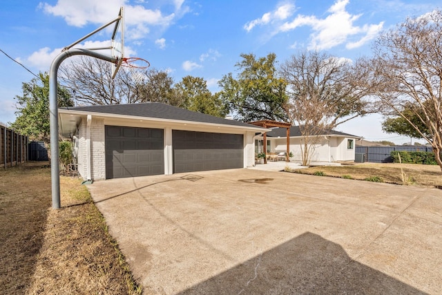 garage with driveway and fence