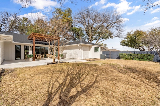 rear view of house with a patio area, brick siding, central AC, and fence