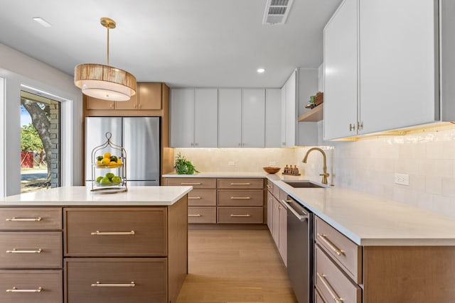 kitchen with open shelves, light countertops, visible vents, appliances with stainless steel finishes, and a sink