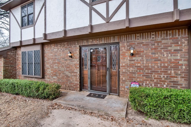 entrance to property with brick siding and stucco siding