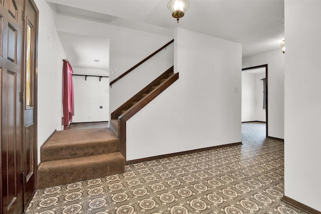 stairs with a textured ceiling and baseboards