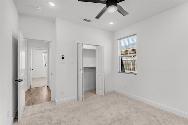 unfurnished bedroom featuring baseboards, visible vents, and light colored carpet