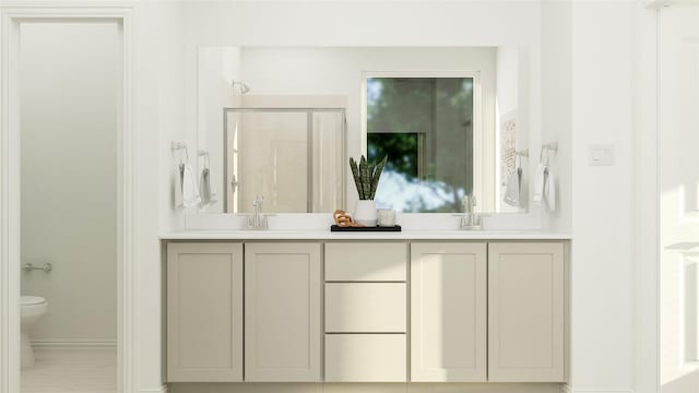 bathroom with a sink, double vanity, a shower stall, and toilet