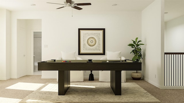 interior space with baseboards, a ceiling fan, and light colored carpet