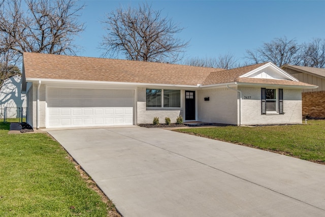 ranch-style home featuring a garage, a shingled roof, concrete driveway, a front yard, and brick siding