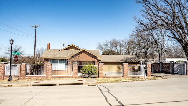 view of front of home featuring a fenced front yard, a gate, and brick siding