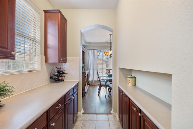 619 Loch View Ct, Rockwall, TX 75087 - kitchen featuring arched walkways, light countertops, decorative backsplash, and healthy amount of natural light