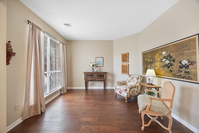 sitting room featuring baseboards, visible vents, and dark wood-style flooring