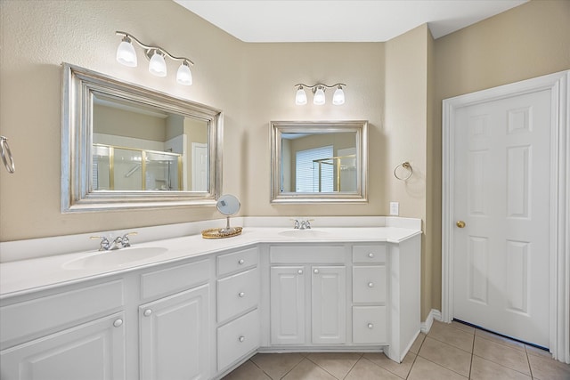 bathroom featuring double vanity, an enclosed shower, a sink, and tile patterned floors