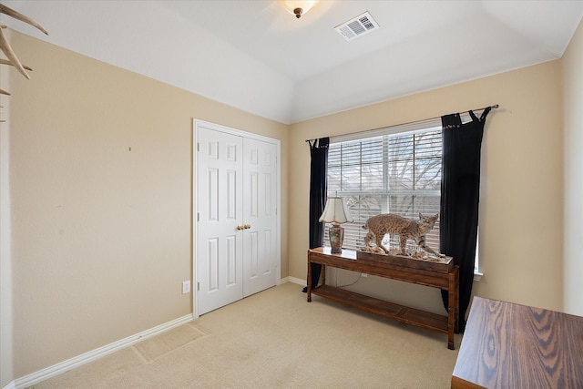 bedroom with lofted ceiling, a closet, visible vents, light carpet, and baseboards