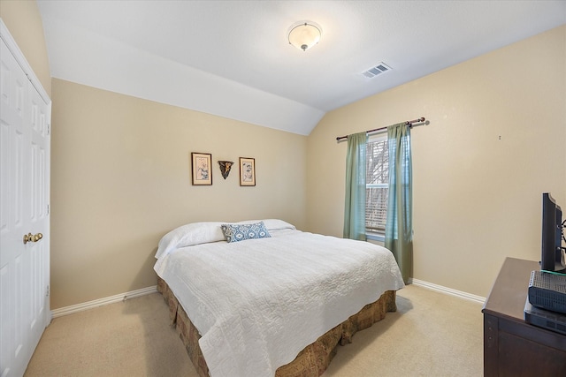 bedroom featuring lofted ceiling, baseboards, visible vents, and light colored carpet