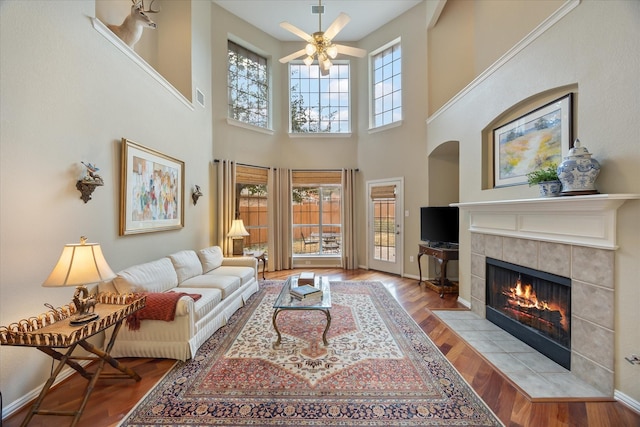 living room featuring visible vents, baseboards, a ceiling fan, light wood-type flooring, and a fireplace