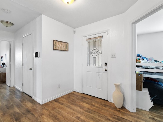 foyer entrance featuring dark wood-type flooring and baseboards