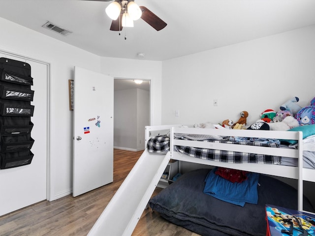 bedroom featuring ceiling fan, visible vents, and wood finished floors