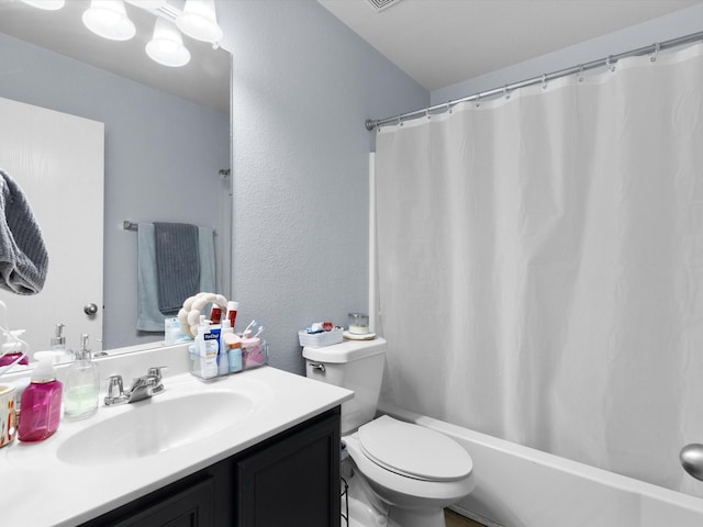 full bathroom with toilet, a textured wall, and vanity