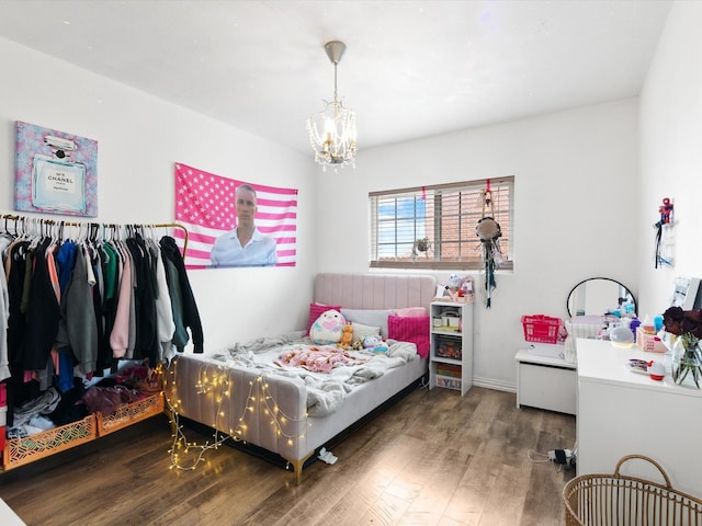 bedroom with a notable chandelier and wood finished floors