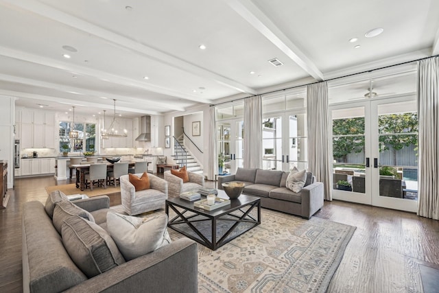 living room featuring a wealth of natural light, light wood-style floors, beam ceiling, and french doors