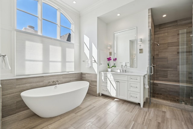 bathroom with a soaking tub, a shower stall, vanity, and crown molding