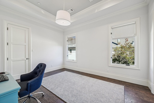 unfurnished office featuring visible vents, baseboards, ornamental molding, a tray ceiling, and dark wood finished floors