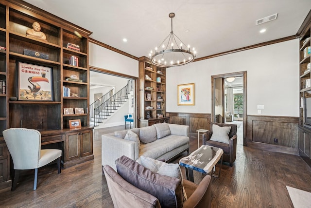 living room featuring visible vents, built in study area, wainscoting, dark wood-type flooring, and built in shelves